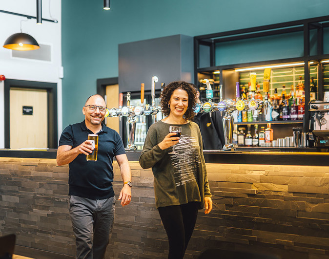 A couple collecting their drinks at the bar in The Drift Inn