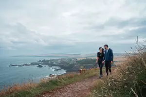 Couple walking along Berwickshire coastline