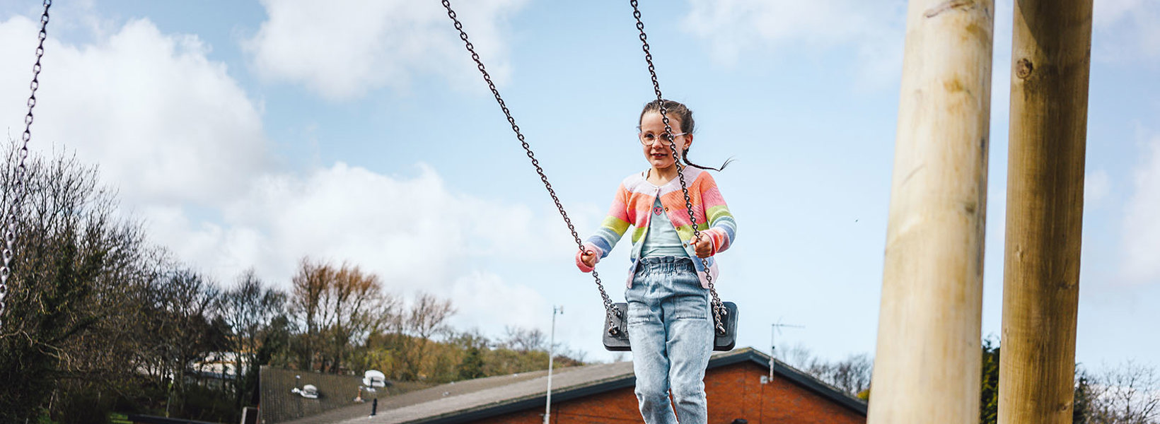 Child on swing at play area at Thurston Manor