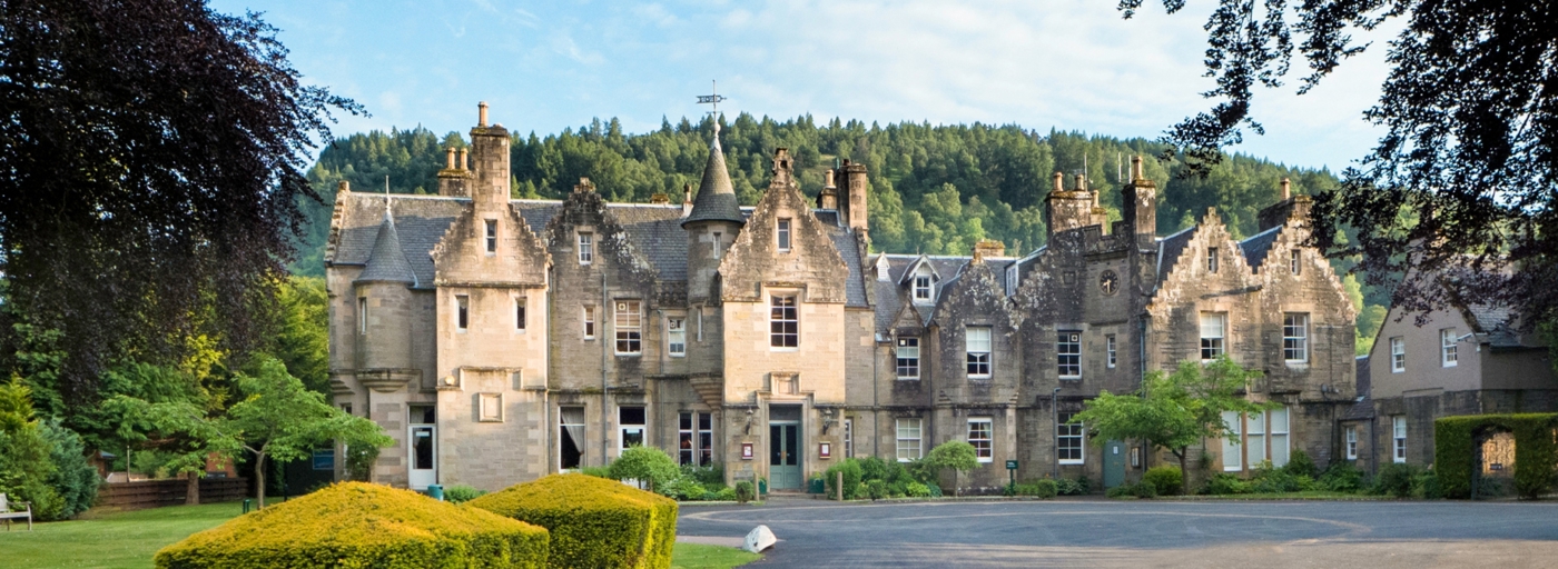 Erigmore House, the grand mansion located at Erigmore Leisure Park in Perthshire, historic building in front of a forest