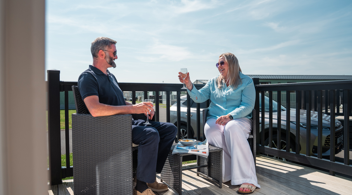 Couple with drinks on lodge decking